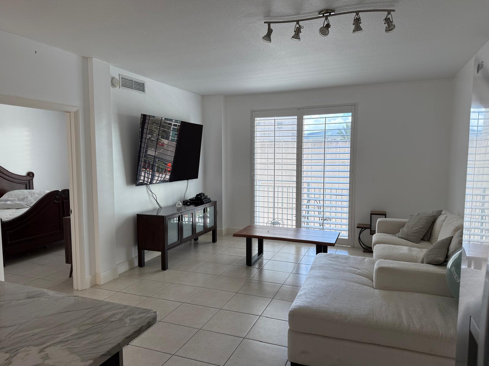 7275 Southwest 90th Way, Unit 311 Miami, FL 33156 - Photo 10 of 17 a living room with furniture and a flat screen tv