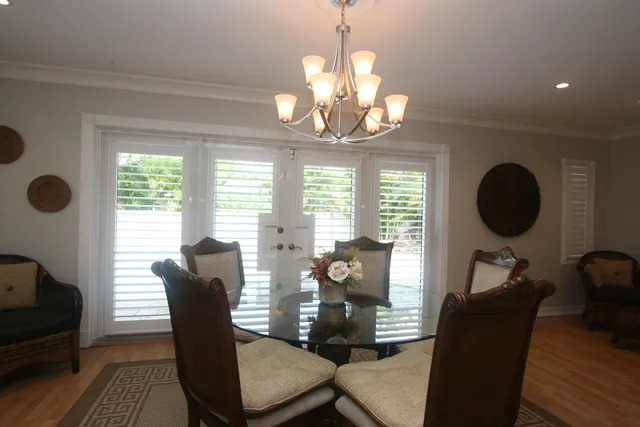 a view of a dining room with furniture a chandelier and wooden floor
