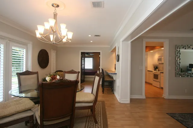 a dining room with furniture a chandelier and wooden floor