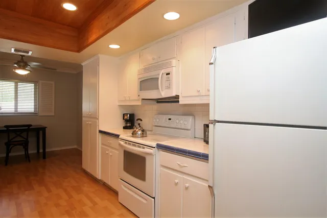 a kitchen with a refrigerator a stove and a dining table