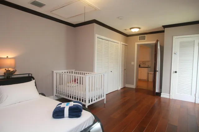 a bedroom with a bed and wooden floor