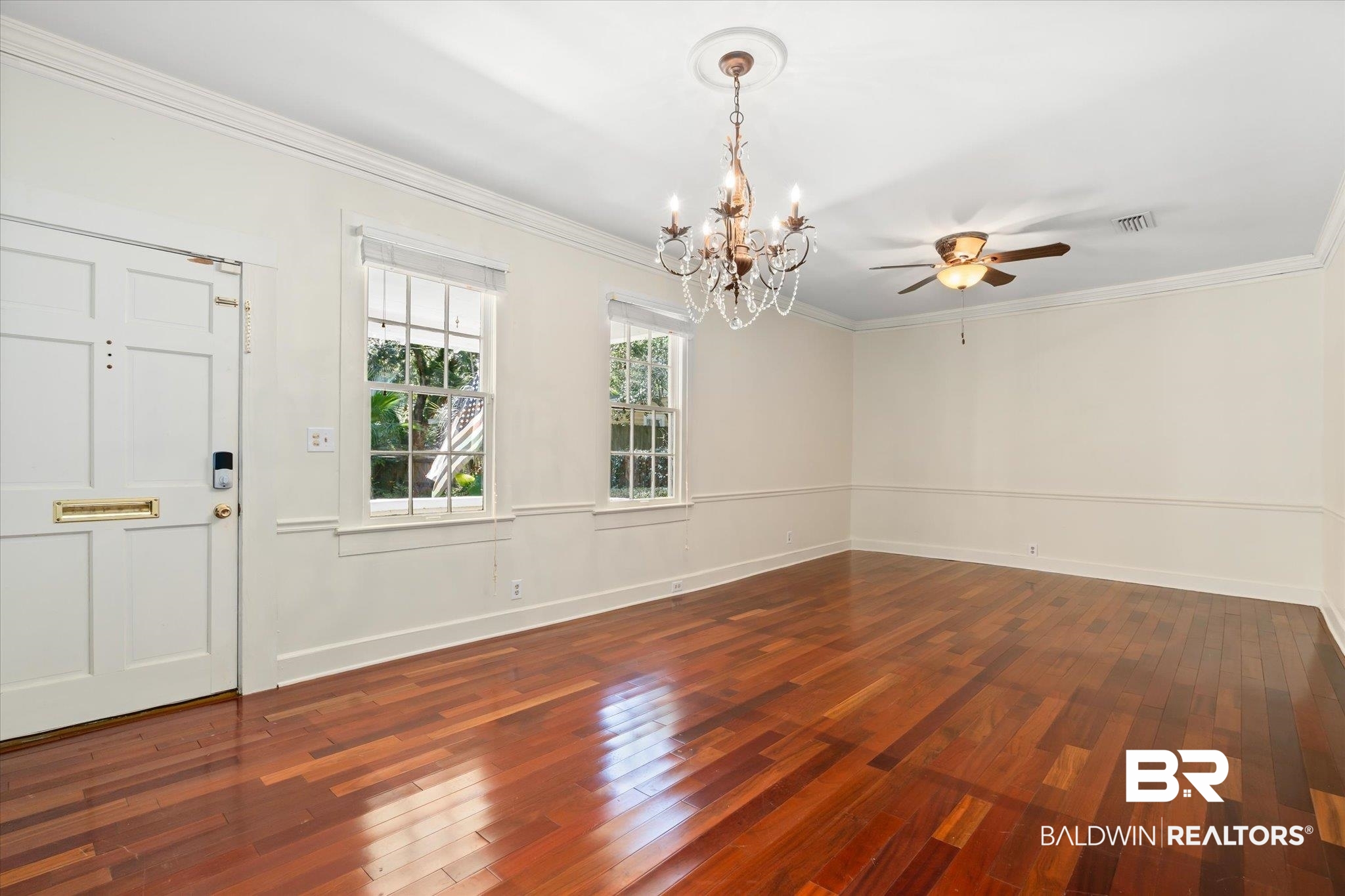 1220 Elmira Street Mobile, AL 36604 - Photo 3 of 20 Empty room with ceiling fan with notable chandelier, crown molding, and dark wood-type flooring