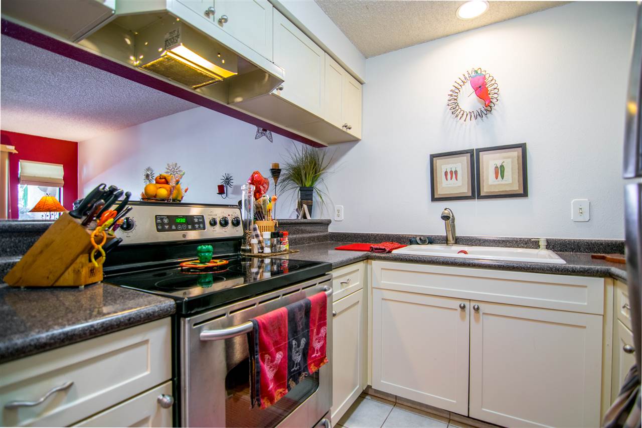 1450 South Kihei Road, Unit A205 Kihei, HI 96753 - Photo 13 of 24 a utility room with stainless steel appliances granite countertop a stove a sink dishwasher and cabinets