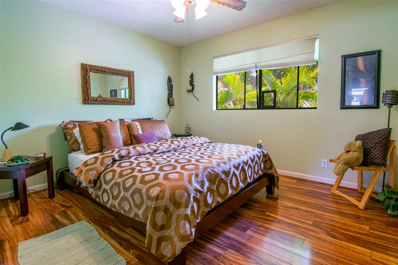 1450 South Kihei Road, Unit A205 Kihei, HI 96753 - Photo 15 of 24 a bedroom with a bed and wooden floor