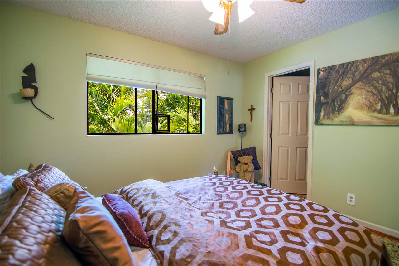 1450 South Kihei Road, Unit A205 Kihei, HI 96753 - Photo 16 of 24 a bedroom with a bed and a painting on the wall