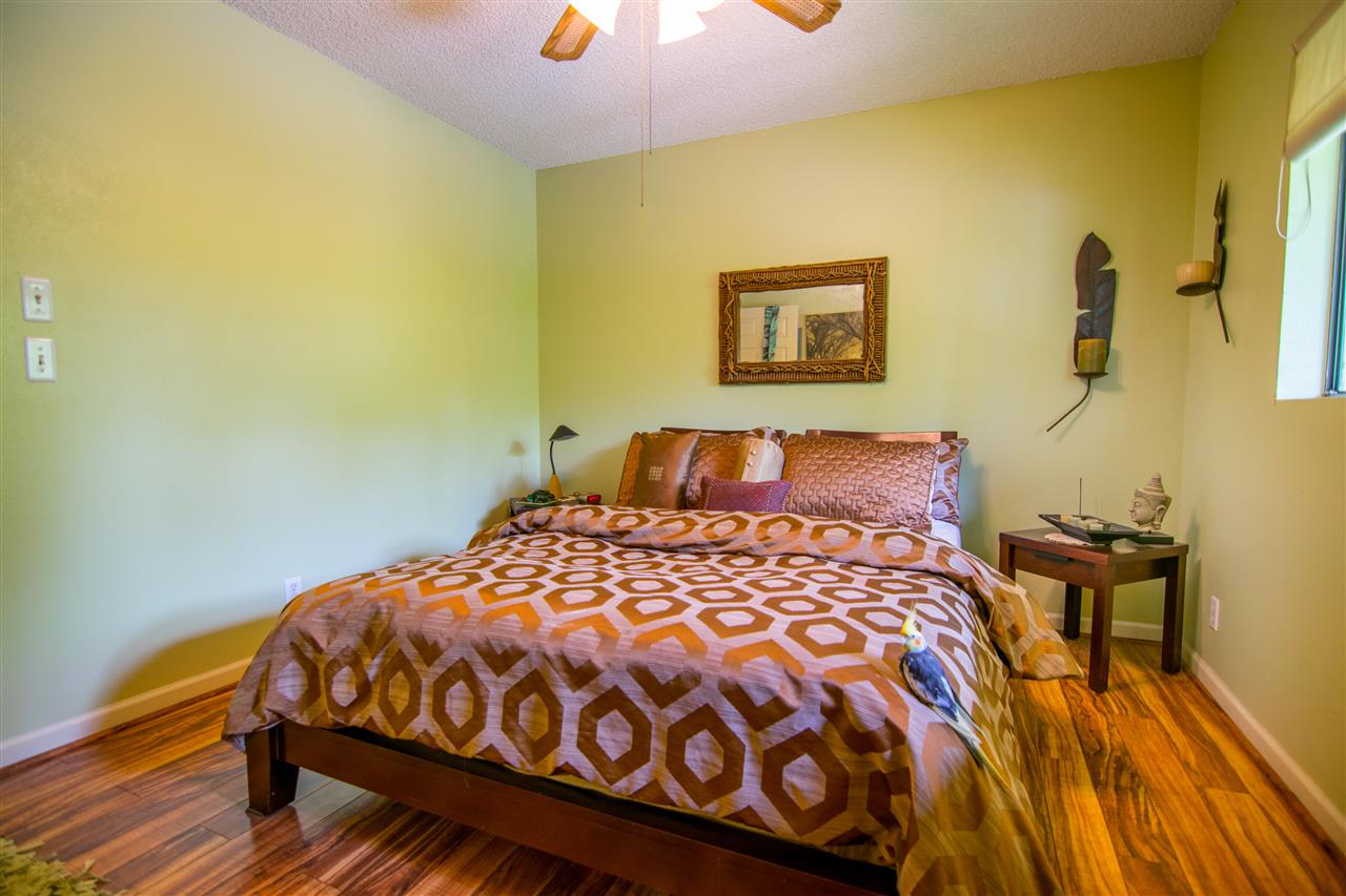 1450 South Kihei Road, Unit A205 Kihei, HI 96753 - Photo 17 of 24 a bedroom with a bed and wooden floor