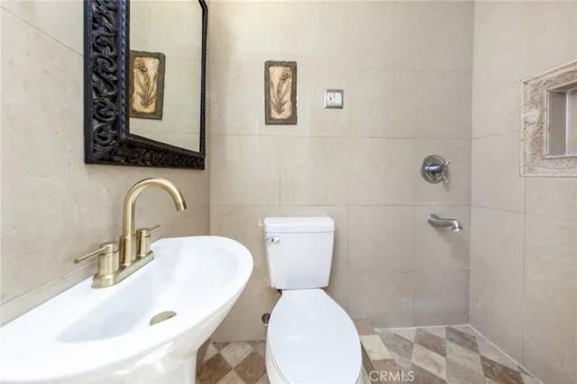 a bathroom with a toilet sink and mirror