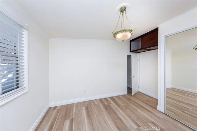 a view of a room with wooden floor ceiling fan and window
