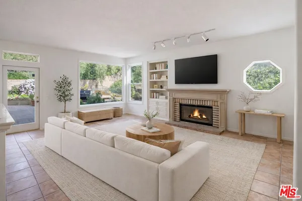a living room with furniture a flat screen tv and a fireplace