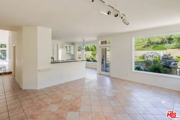 a view of a big room with windows and chandelier fan