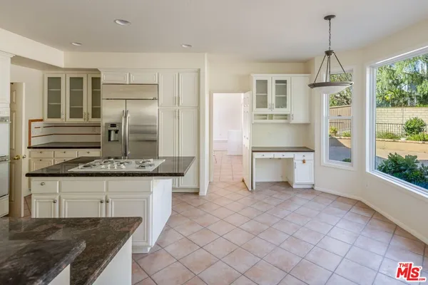 a kitchen with granite countertop a sink stainless steel appliances and cabinets