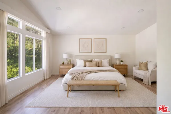 a bedroom with a bed and a large window