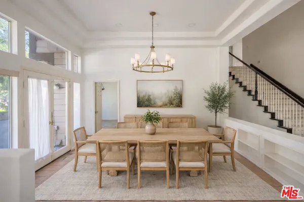 a dining room with furniture a chandelier and wooden floor