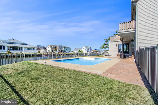 a view of an empty room with wooden floor and a fireplace
