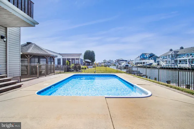 an empty room with wooden floor fireplace and windows
