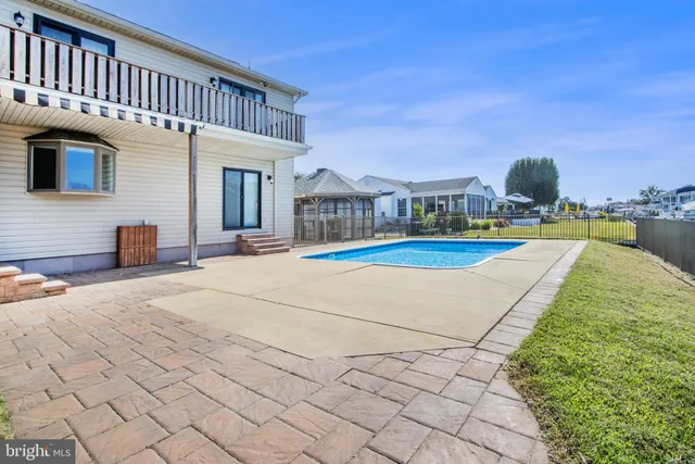 a view of a room with wooden floor fireplace and windows