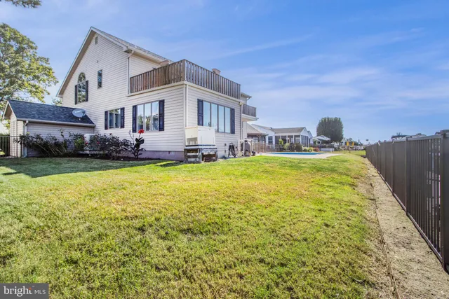 a view of kitchen with stainless steel appliances wooden floor dining table and chairs