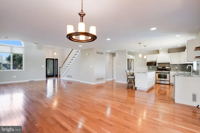 a view of a room with a hanging light and kitchen