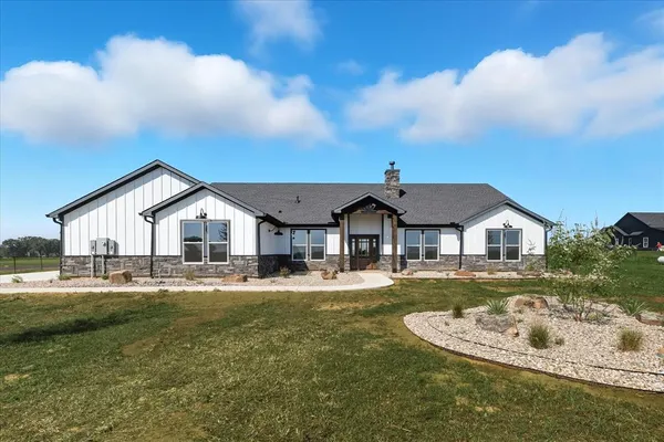 a view of a house with a big yard and large trees