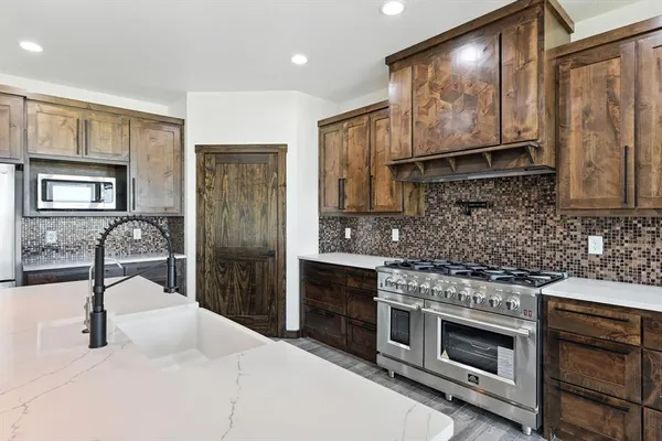 a kitchen with stainless steel appliances granite countertop a stove a sink and a refrigerator