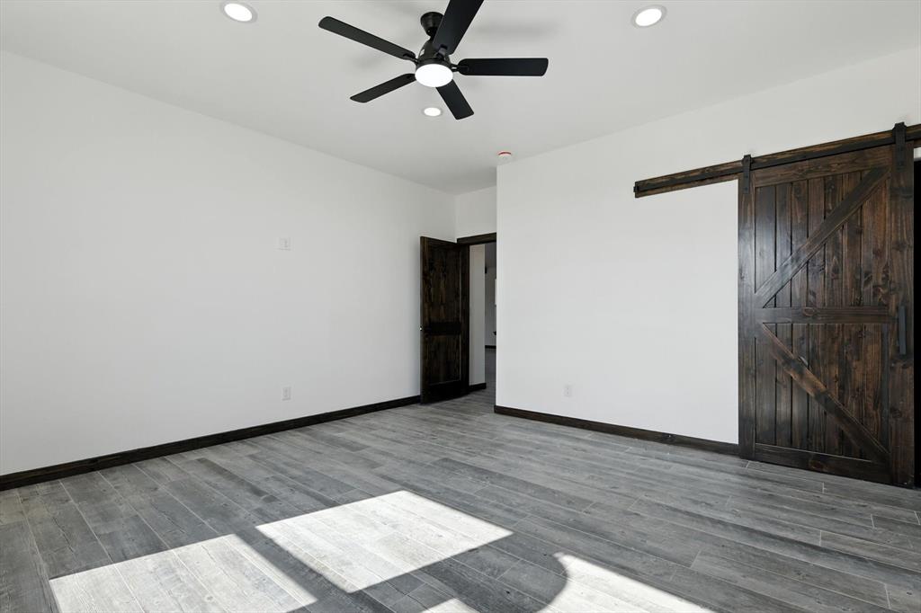 835 Clb Lk Road Whitesboro, TX 76273 - Photo 23 of 33 a view of an empty room with wooden floor and a ceiling fan