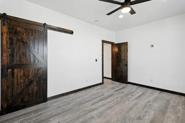 a view of a room with wooden floor and a ceiling fan