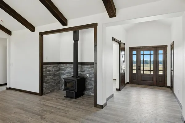 a view of an empty room with window and wooden floor