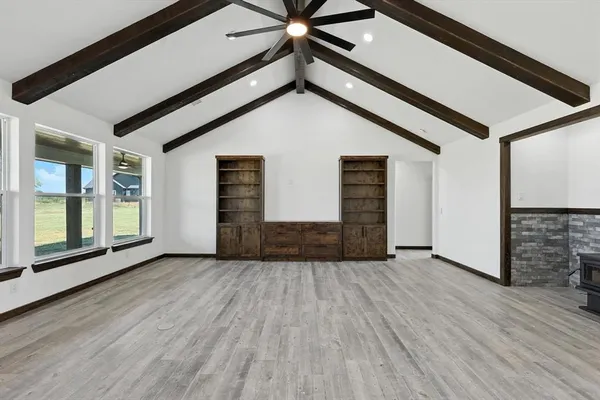 a view of a livingroom with wooden floor and a ceiling fan
