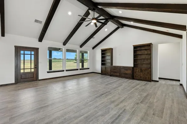 a view of empty room with wooden floor