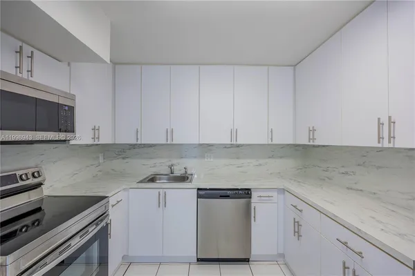 a kitchen with granite countertop white cabinets and stainless steel appliances