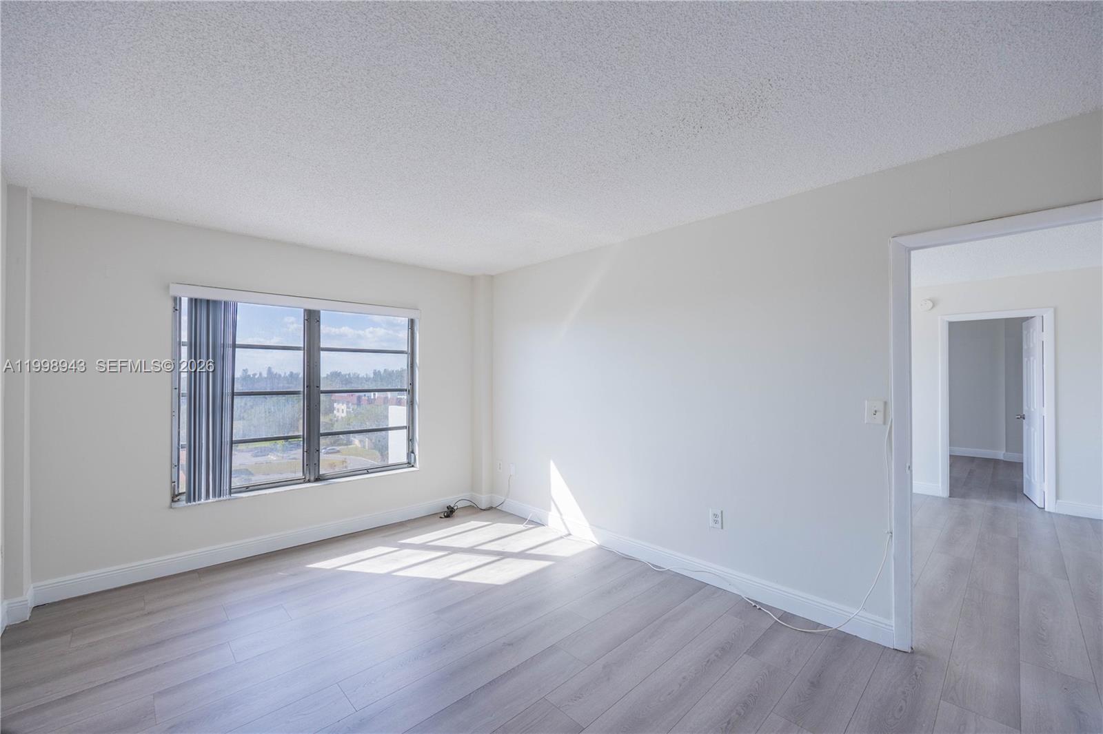 4164 Inverrary Drive, Unit 812 Lauderhill, FL 33319 - Photo 16 of 21 an empty room with wooden floor and windows