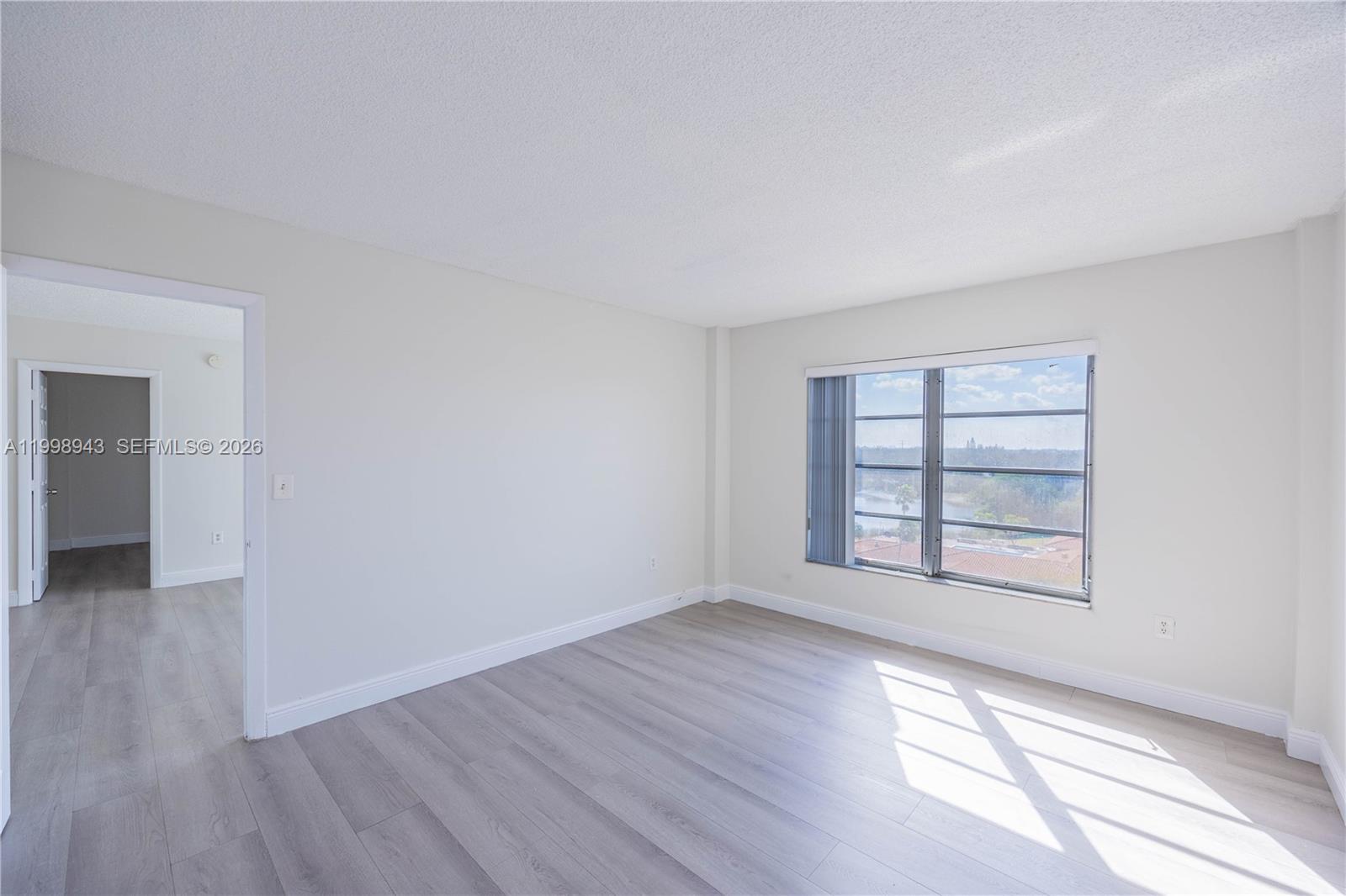 4164 Inverrary Drive, Unit 812 Lauderhill, FL 33319 - Photo 17 of 21 an empty room with wooden floor and windows