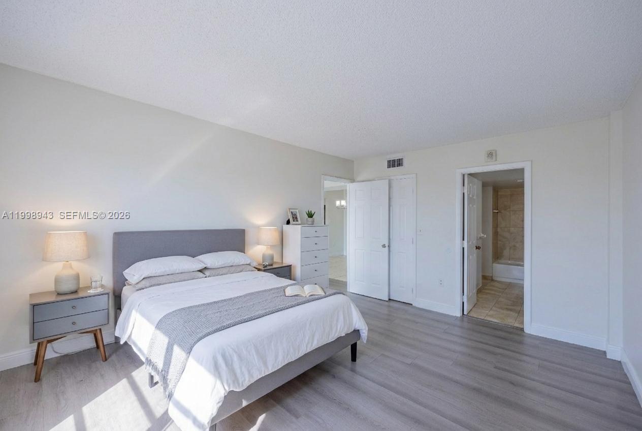 4164 Inverrary Drive, Unit 812 Lauderhill, FL 33319 - Photo 4 of 21 a spacious bedroom with a bed and a lamp