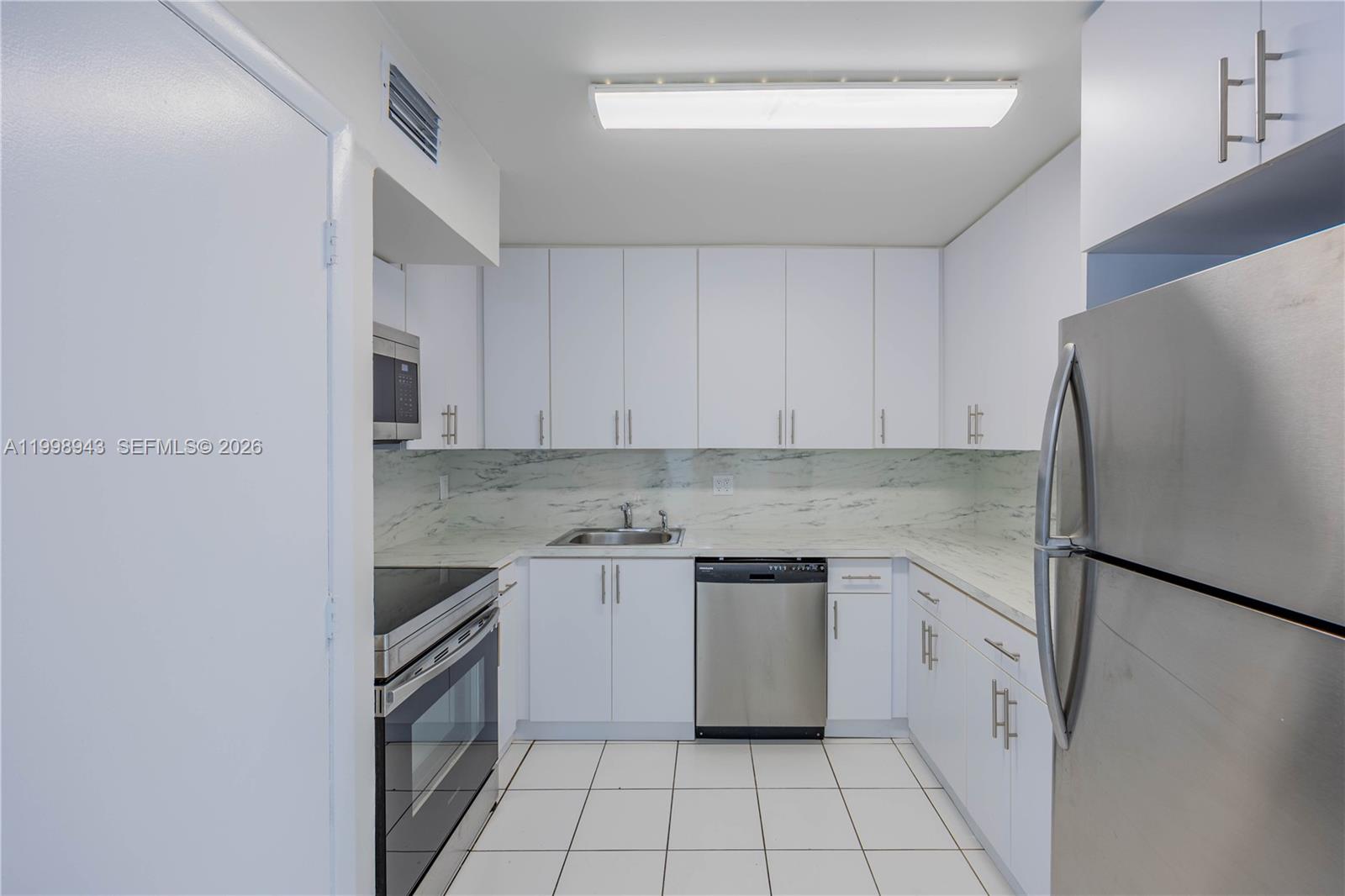 4164 Inverrary Drive, Unit 812 Lauderhill, FL 33319 - Photo 10 of 21 a kitchen with a stove a refrigerator and a sink