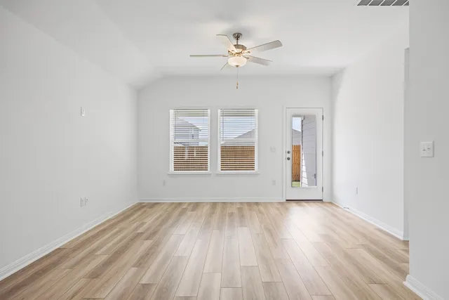 a view of a kitchen with wooden floor and a ceiling fan