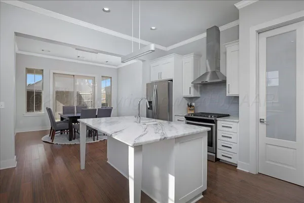 a kitchen with a stove a table and chairs in it