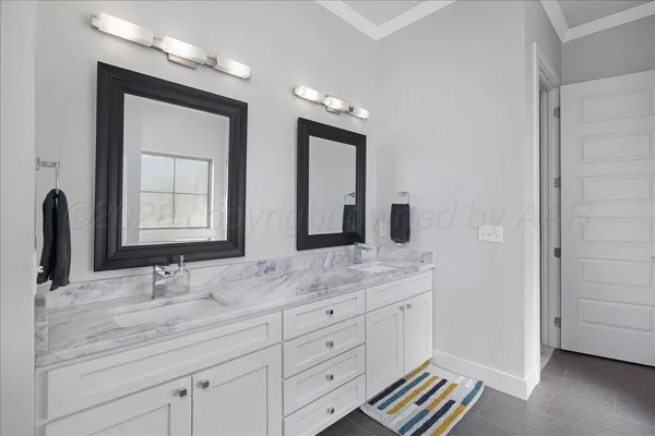 a bathroom with a granite countertop double vanity sink and mirror