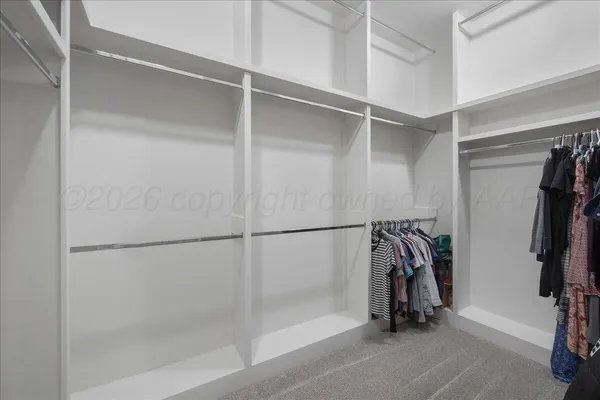 a view of walk in closet with clothes