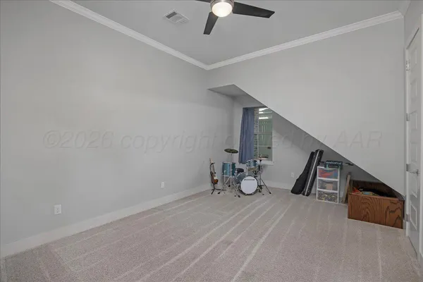 a very nice looking room with a chair and a ceiling fan