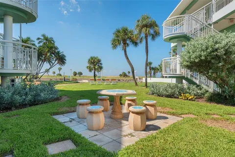 a view of a fountain with a table and chairs under an umbrella