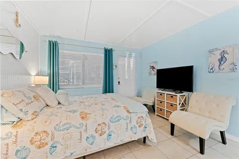 a bedroom with a bed and a flat screen tv