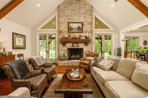 a living room with furniture a large window and a fireplace