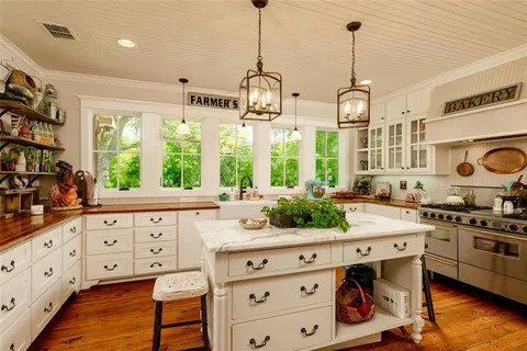 a kitchen with granite countertop a sink window and cabinets