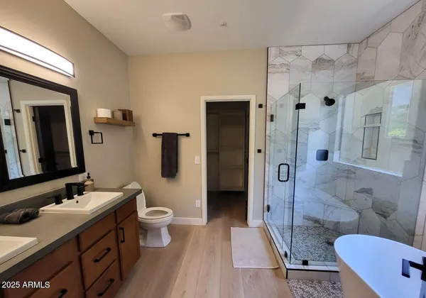 a bathroom with a double vanity sink toilet mirror and shower
