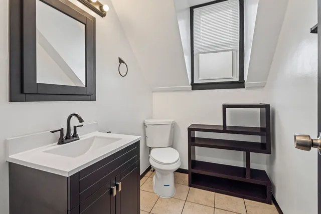 a bathroom with a toilet sink and mirror