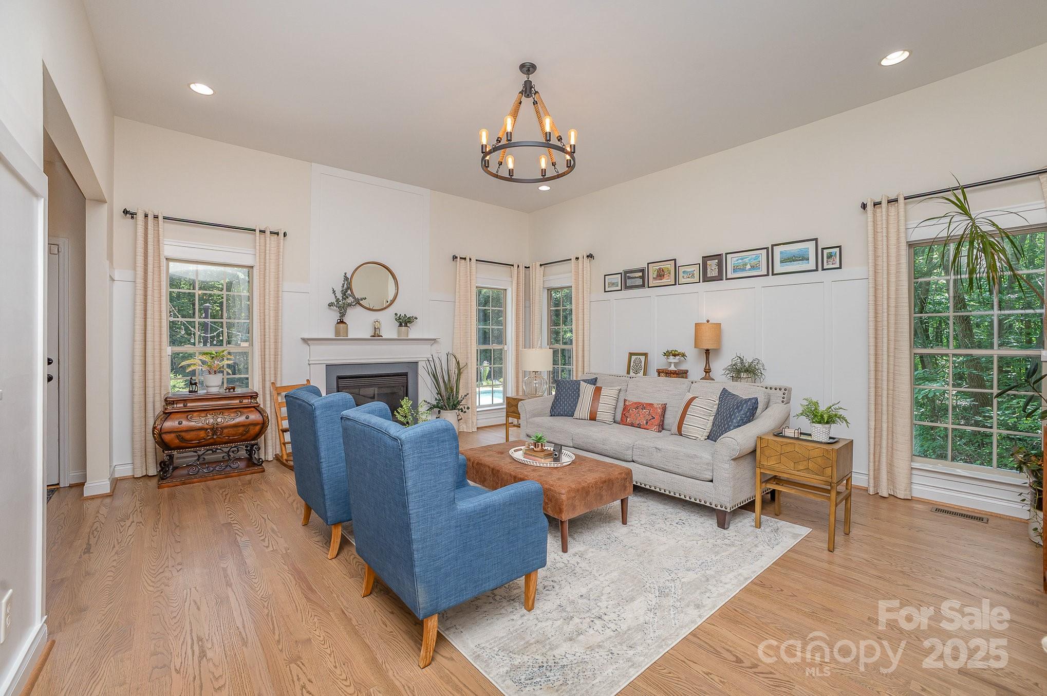 8121 Cane Pointe Lane Waxhaw, NC 28173 - Photo 11 of 39 a living room with furniture a fireplace and a chandelier