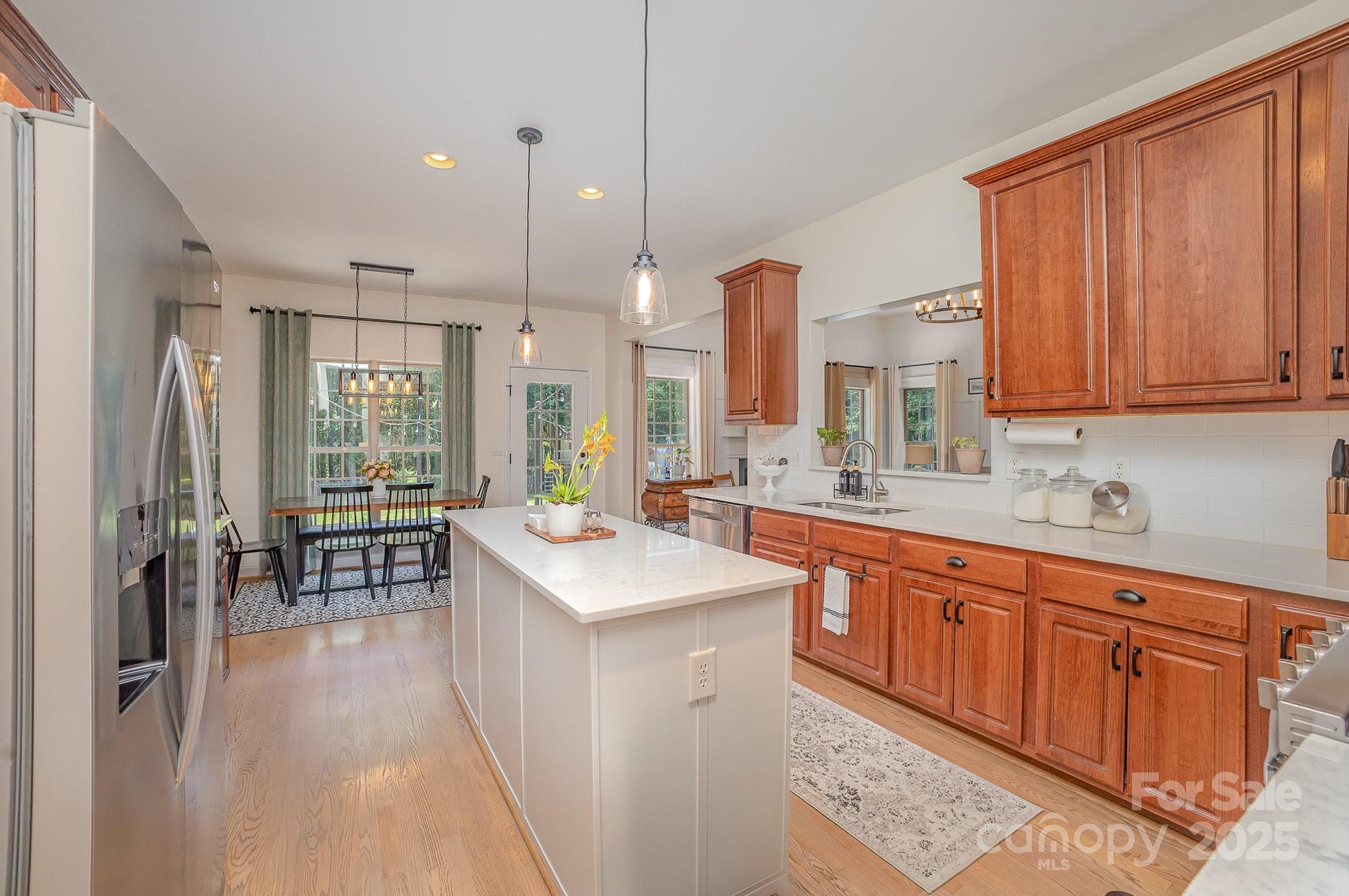 8121 Cane Pointe Lane Waxhaw, NC 28173 - Photo 14 of 39 a kitchen with kitchen island granite countertop a sink stove and cabinets