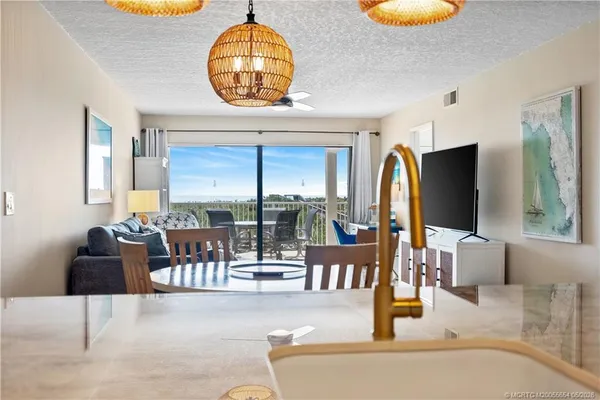 a living room with couches a table and a large mirror with wooden floor