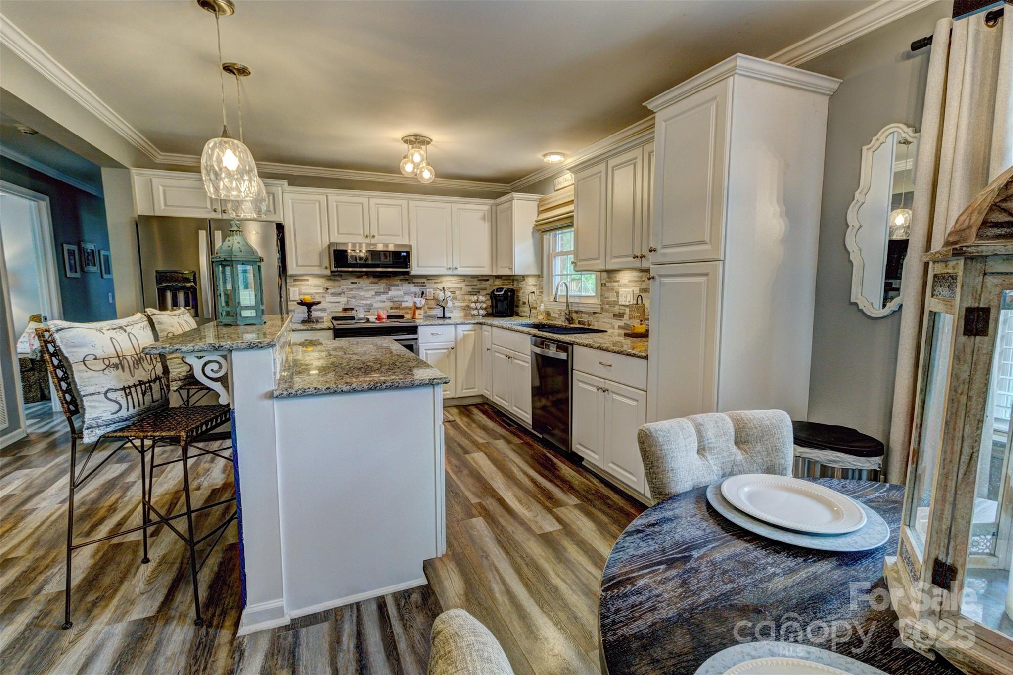 800 Sunset Road Cherryville, NC 28021 - Photo 8 of 20 a kitchen with stainless steel appliances a refrigerator a stove a sink dishwasher and white cabinets with wooden floor