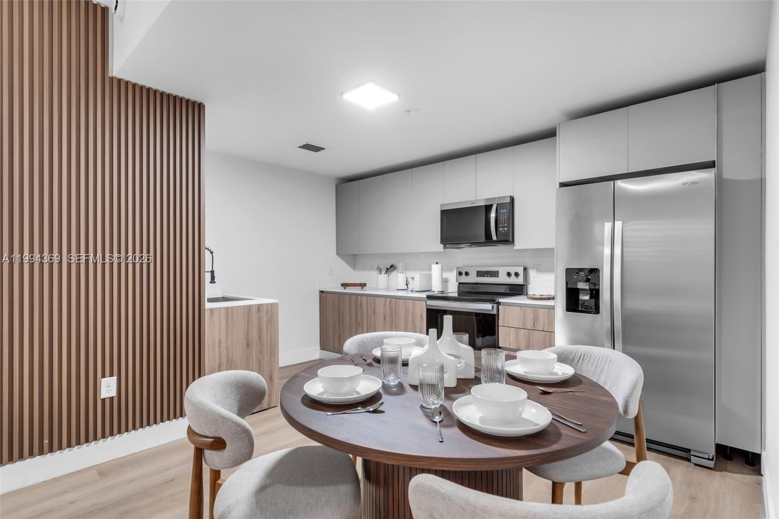 3728 Northwest 19th Avenue, Unit 101 Miami, FL 33142 - Photo 1 of 11 a dining room with furniture and kitchen view